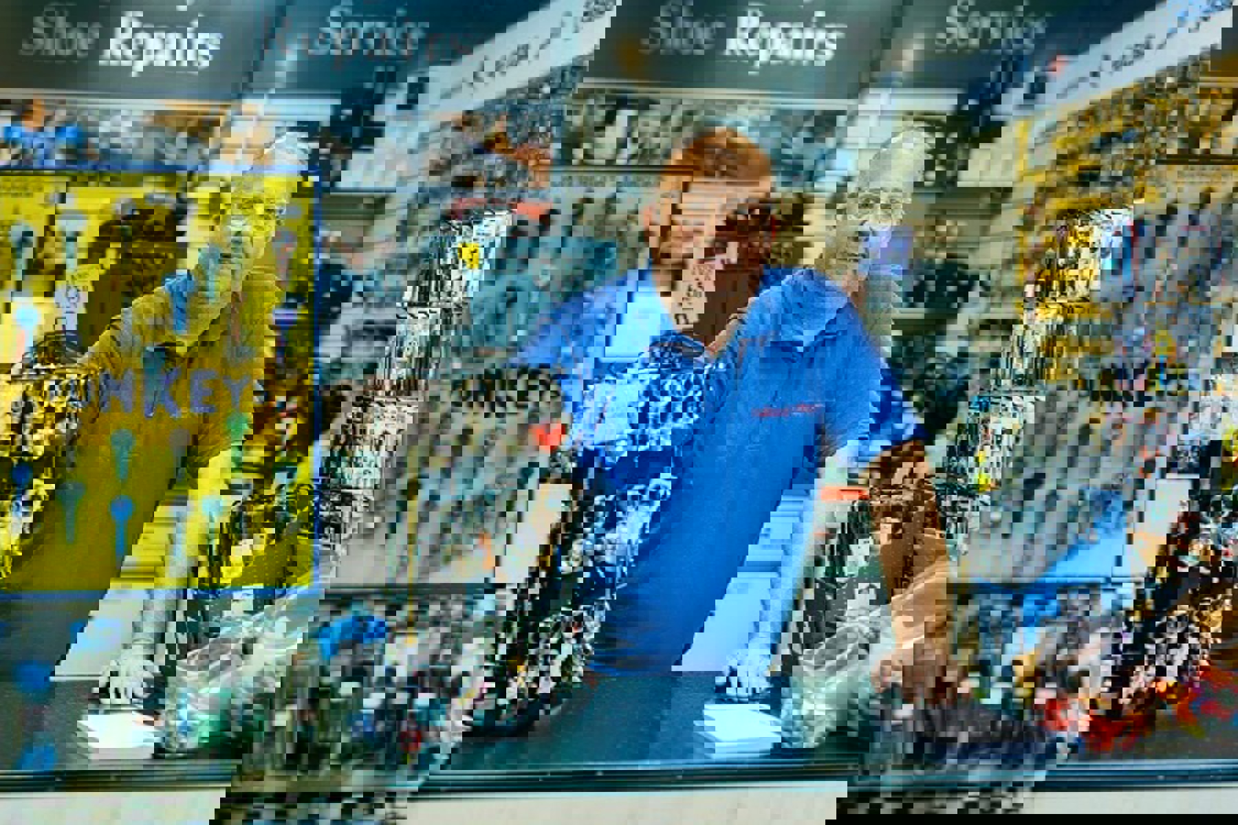 Man At Counter Of Shoe Repair Shop