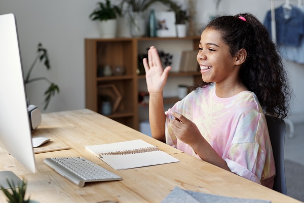 Young Girl Smiling Waving At Laptop