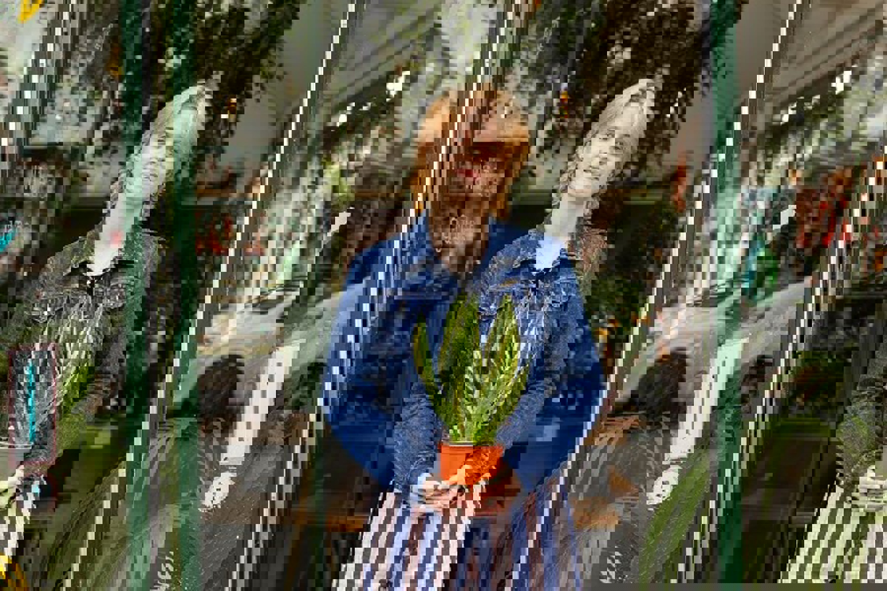 Woman In Shop Door Holding Plant