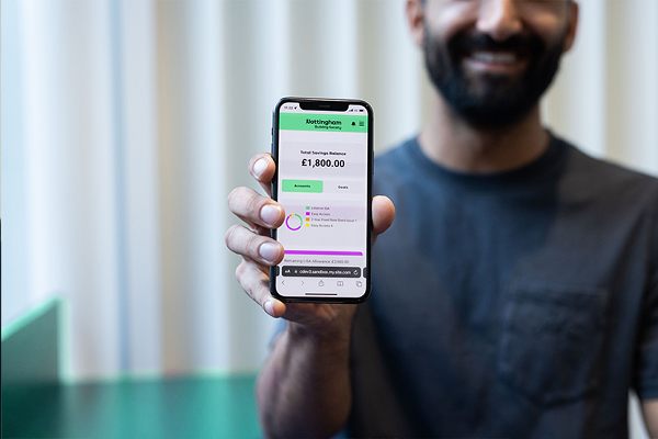 Colleague Holding Phone Showing NBS App