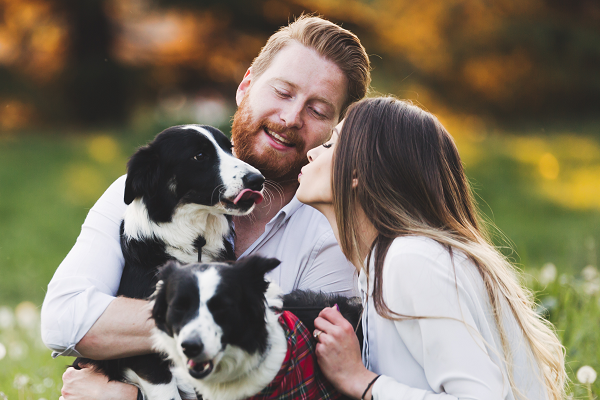 Young Couple Smiling Outdoors With Dog