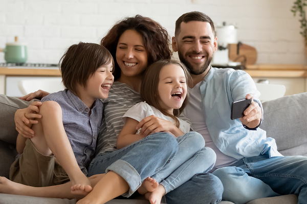 Young Family Looking At Mobile Laughing